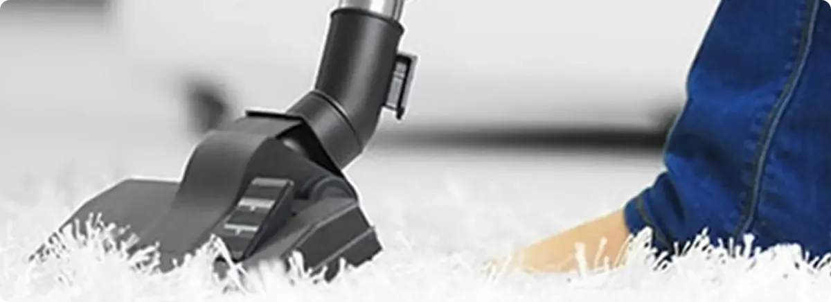 Close-up of a professional vacuuming a white carpet in Tustin.